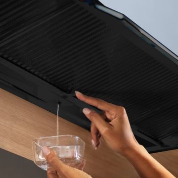 Vue détaillée du système Zero Drip de la hotte intégrable WESCO EVM 224 : l’eau de condensation est vidée du bac de récupération dans un verre.